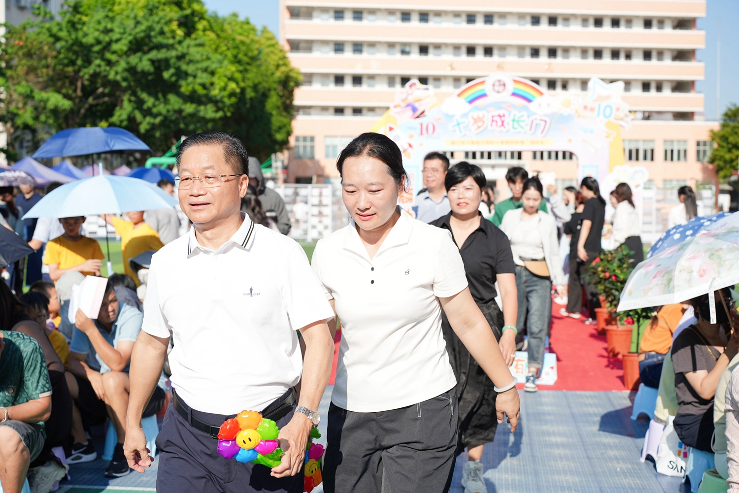 1779957465400243.jpg 图3 校长带领老师走过成长门.JPG